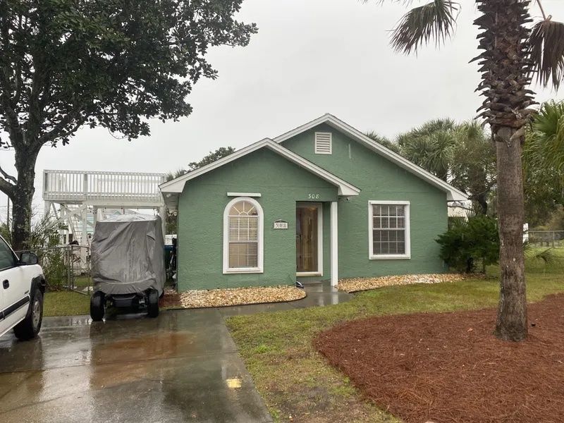 Original green stucco house before renovation.