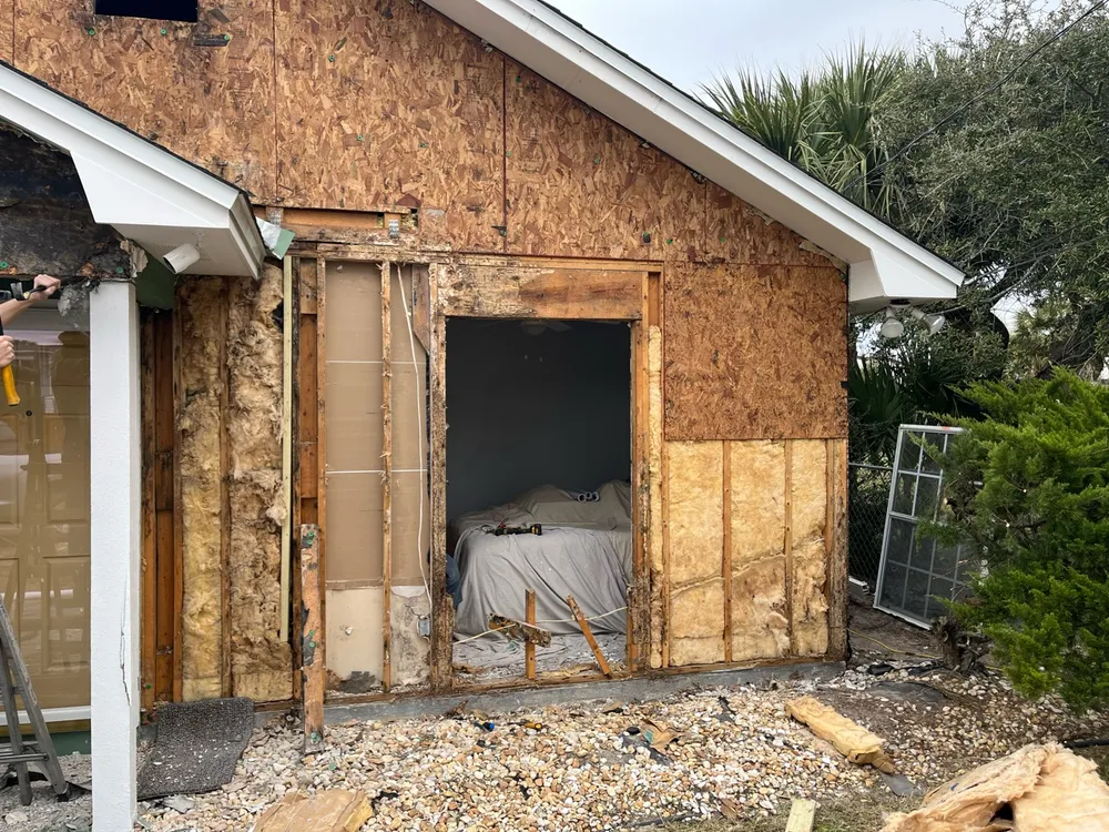 Exposed window opening and damaged framing after removal of exterior finishes.