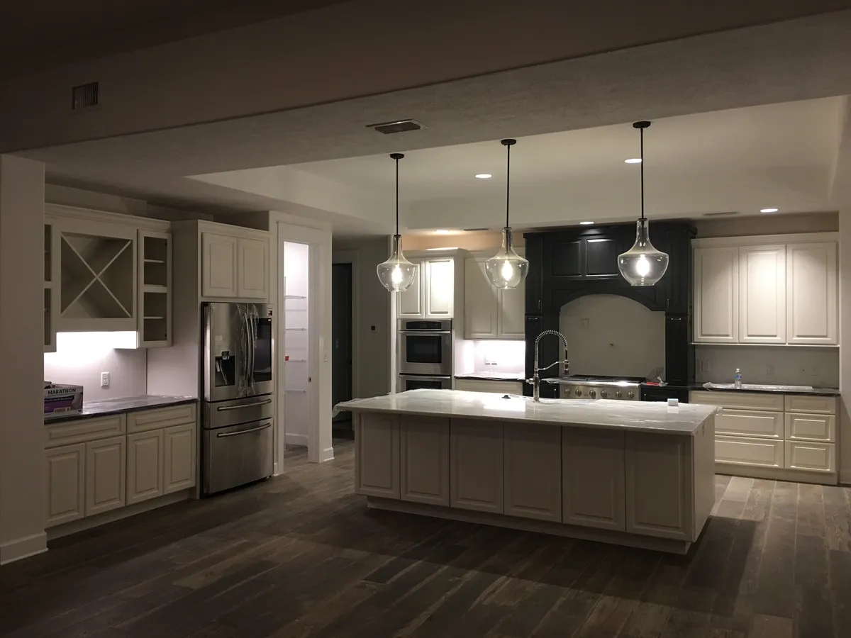 Kitchen with cream cabinetry, a large island, pendant lights, and a recessed ceiling, near the end of construction.
