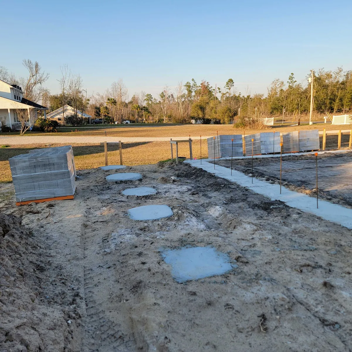 Square concrete pad footings and a strip footing poured across the site.