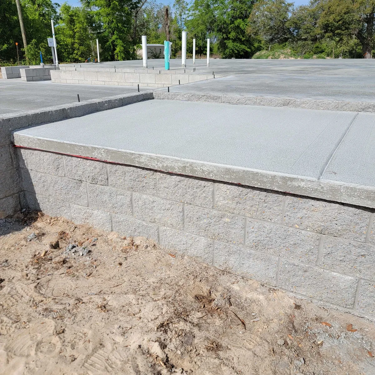 Split-face block stemwall with the smooth edge of the poured concrete slab above it.