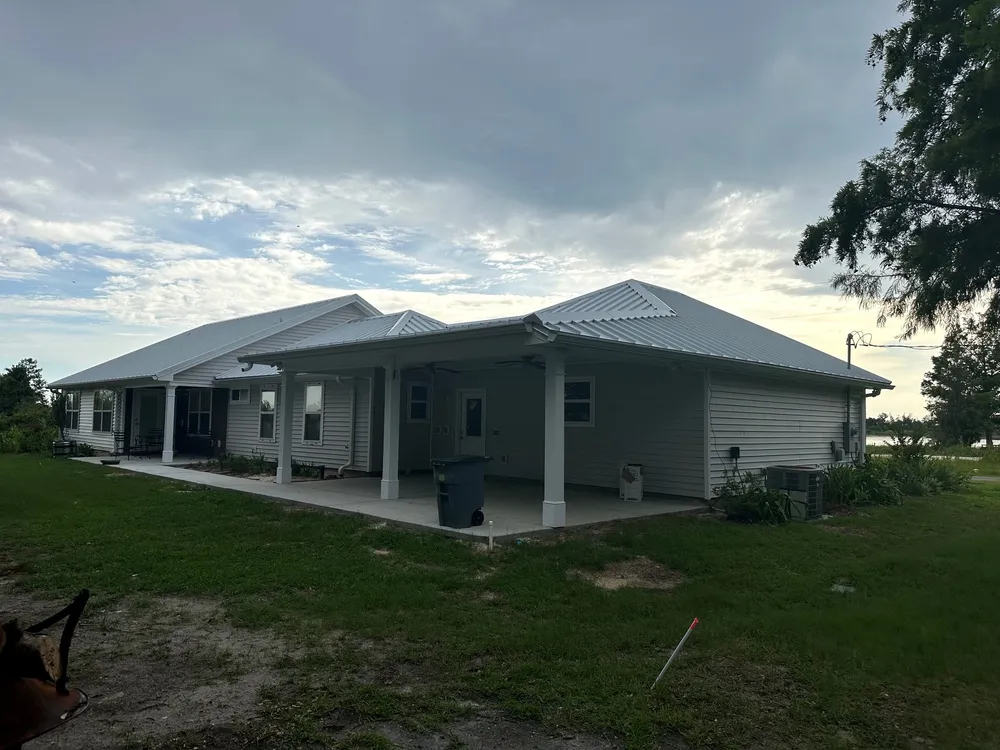 Completed rear covered porch with trimmed columns and a metal roof at a Deerpoint Lake home.