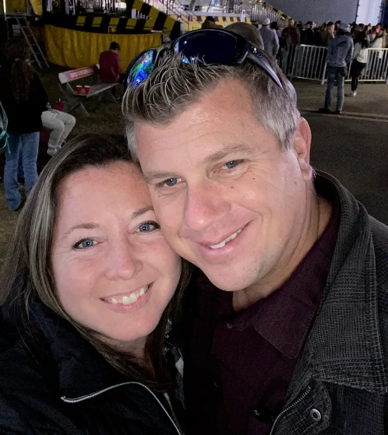 Guy and Kendra smiling together at a fair.