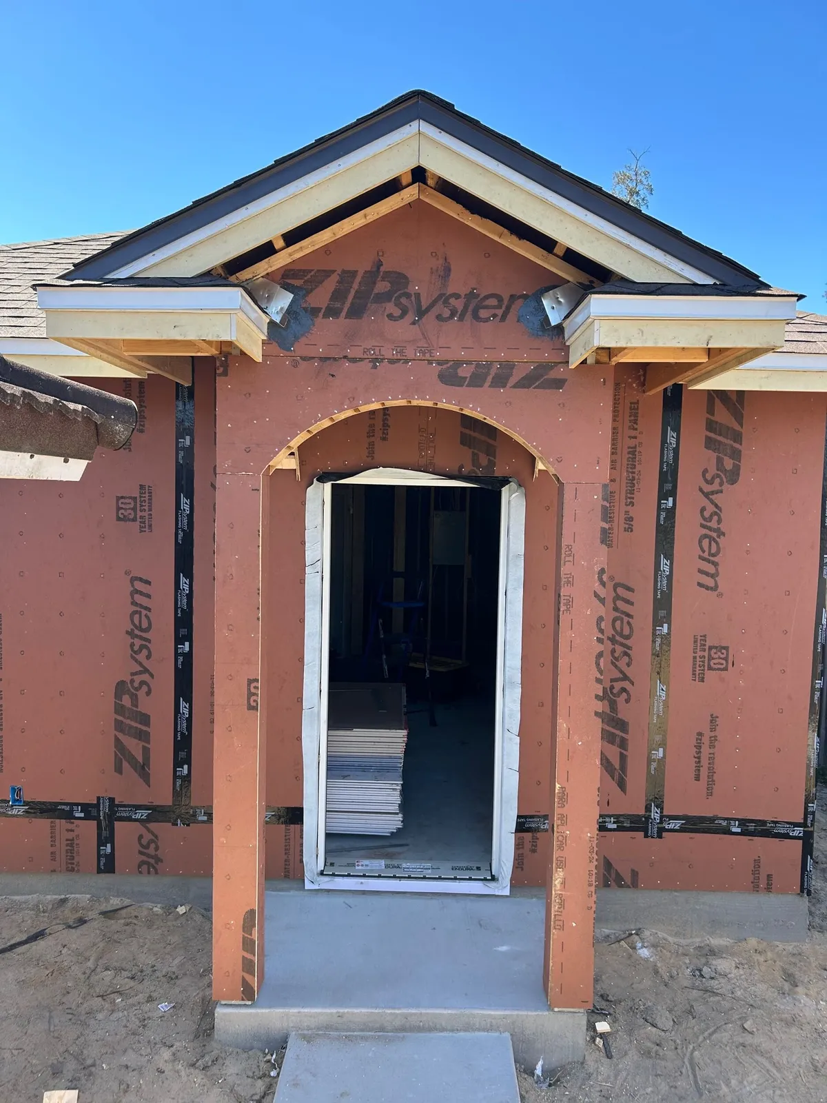 The entry arch framed and sheathed, with the gable return framing above and the door opening below.