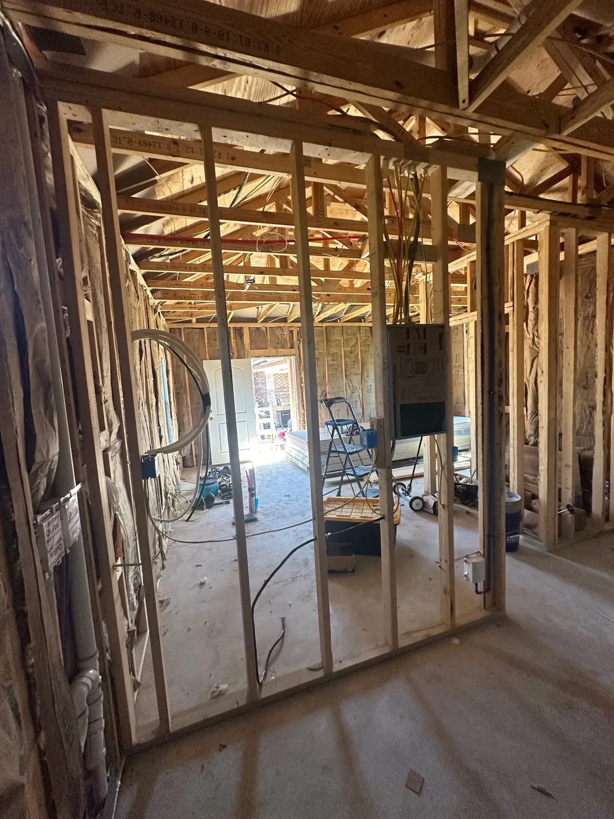 Interior stud walls and ceiling framing, with wiring run to an electrical panel.