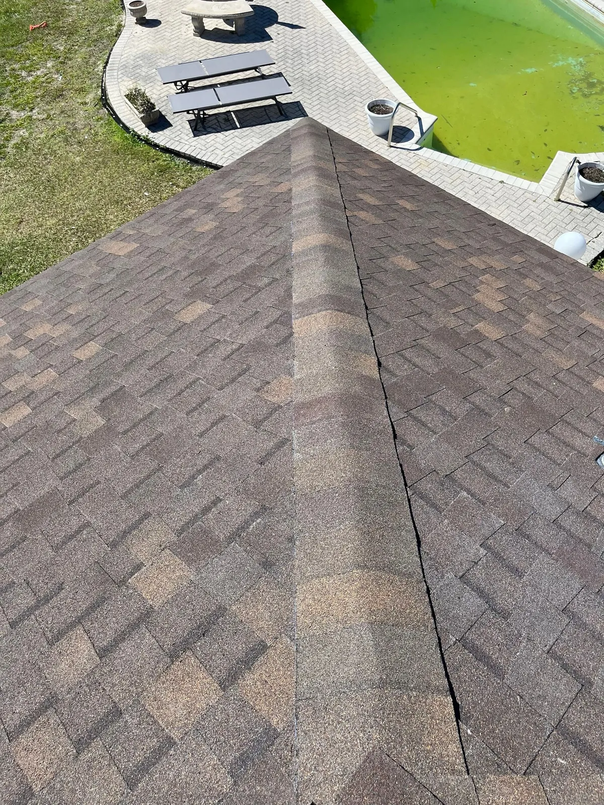Shingled hip roof seen from above, with the backyard below.