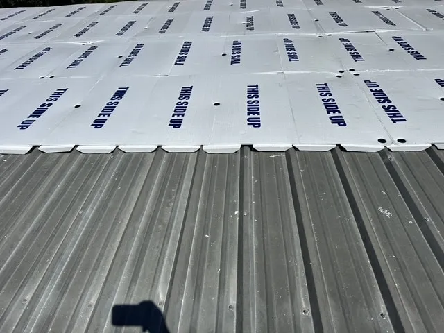 Flute fill set between the ribs of the metal roof with cover board laid over it.